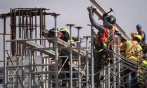 Construction workers work at the site of a condo tower under construction, in Delta, B.C., on Wednesday, July 2, 2025.