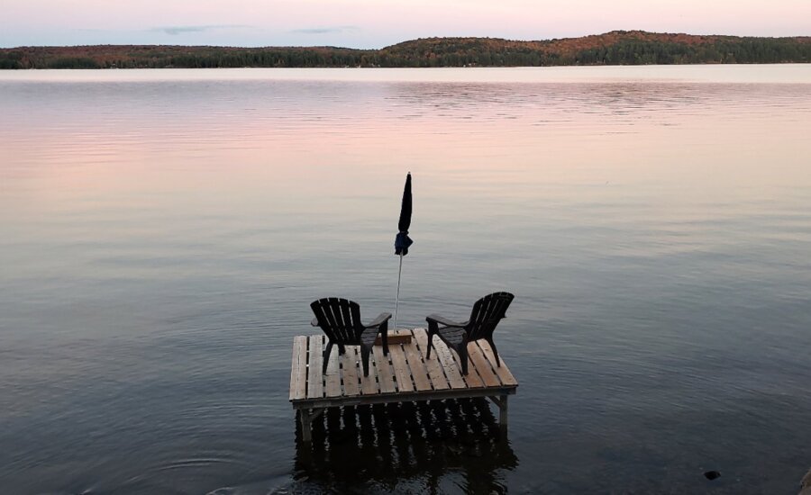 Muskoka chairs sit on a dock looking over Boshkung Lake, in Algonquin Highlands, Ont., Monday, Oct. 5, 2020.