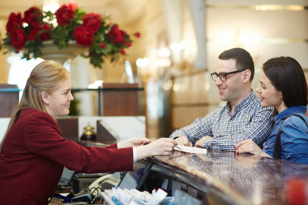 A hotel clerk helps a man and woman check in.