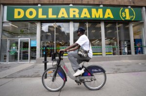 A person cycles past a Dollarama store in Montreal, Wednesday, June 7, 2023.