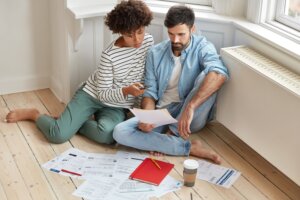 couple examines mortgage renewal documents on living room floor