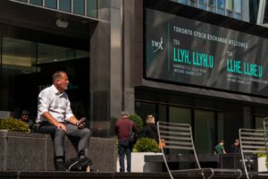 People sit outside the TMX Market Centre in Toronto, Wednesday, Sept. 11, 2024.