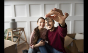 Couple holding up a key to their new home.