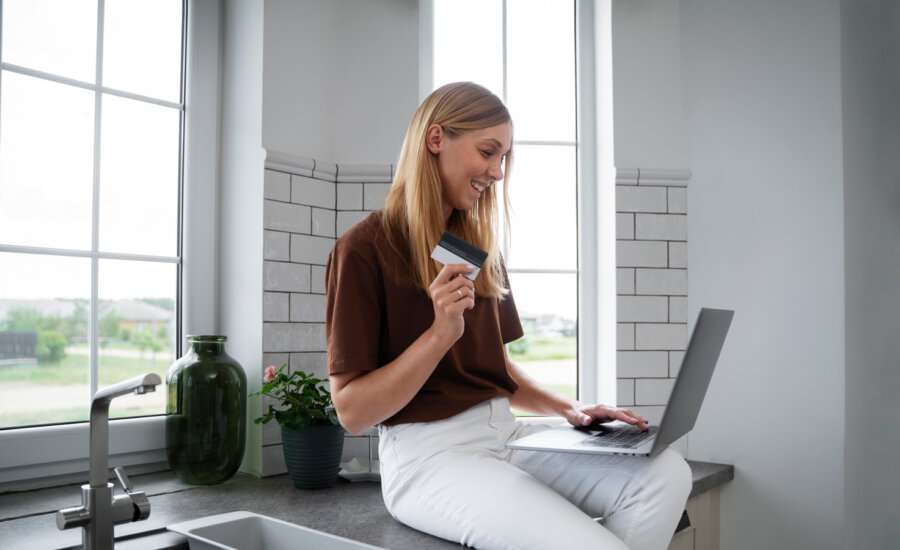 A Canadian woman banking on her laptop at home.