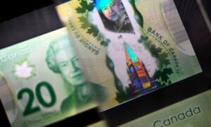 A magnifying glass enlarges the holographic image of Parliament Hill's Peace Tower on a 20 dollar bill issued at the Bank of Canada Museum in Ottawa on Wednesday, Sept. 4, 2024
