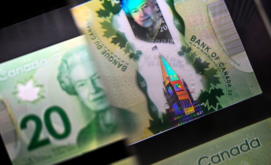 A magnifying glass enlarges the holographic image of Parliament Hill's Peace Tower on a 20 dollar bill issued at the Bank of Canada Museum in Ottawa on Wednesday, Sept. 4, 2024