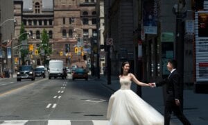 A couple poses for photographs in their wedding outfits during photo shoot in the middle of a street in Toronto on Friday, June 5, 2020.