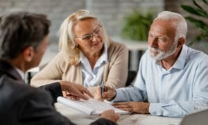 Older couple having a discussion with a younger man over paperwork.