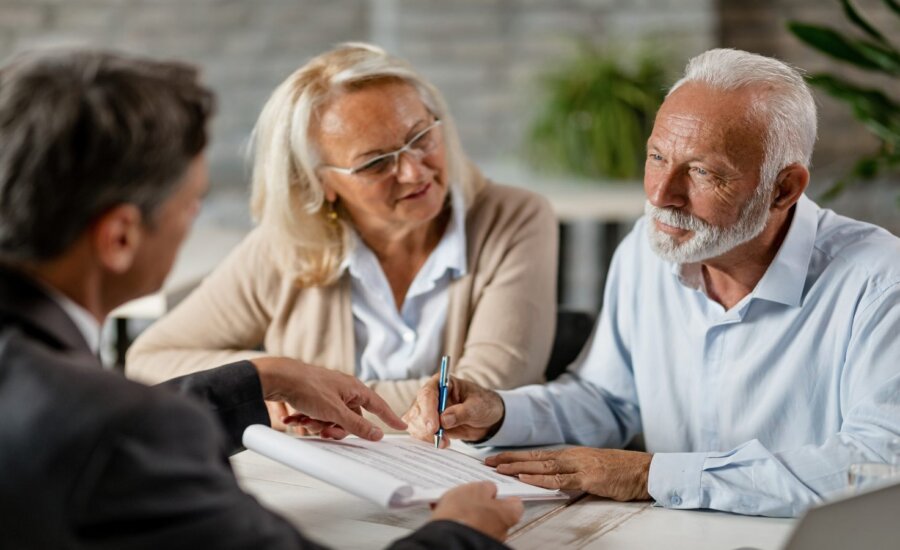 Older couple having a discussion with a younger man over paperwork.