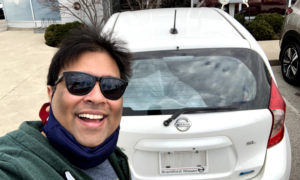 Vickram Agarwal and his first car in Canada, a used white Nissan hatchback