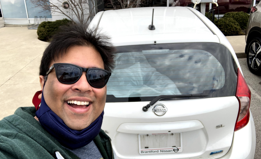 Vickram Agarwal and his first car in Canada, a used white Nissan hatchback