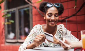 A woman uses her credit card to pay at a cafe