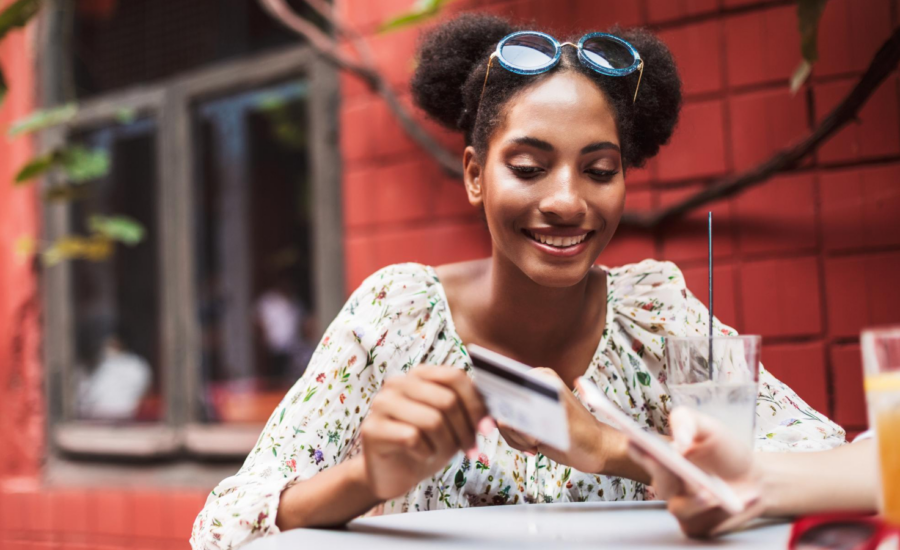 A woman uses her credit card to pay at a cafe