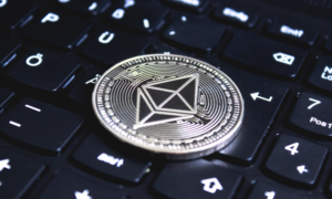 A silver ethereum coin sits on a computer keyboard