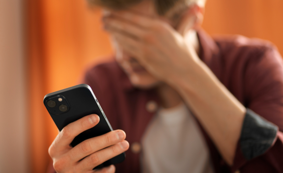 A man looks worried as he checks a credit bill on his phone