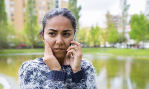 A worried-looking young woman talks on her phone