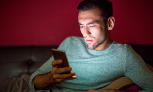 A man looks worried as he checks his online CRA account on his phone