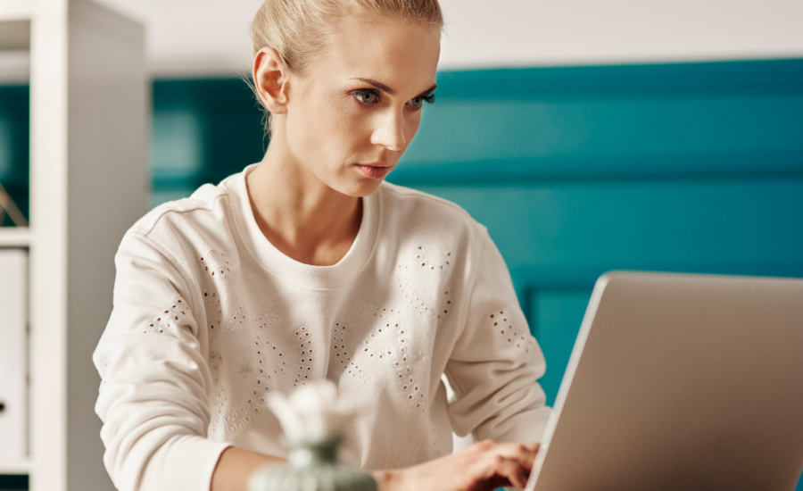 Blonde woman works at a laptop