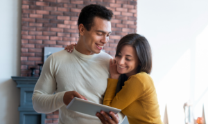 A young man and woman check their registered accounts on a tablet
