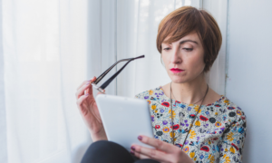 A woman reads messages on her tablet