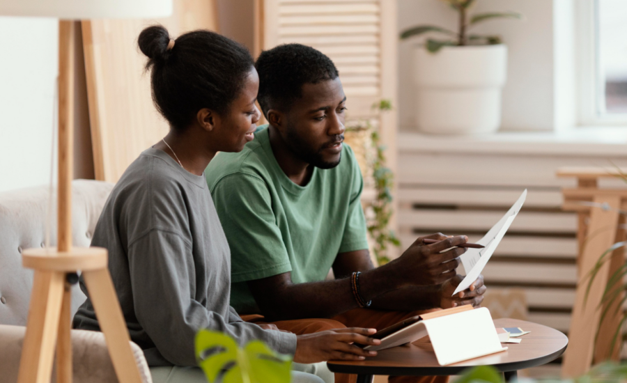 A man and woman discuss a document in their living room