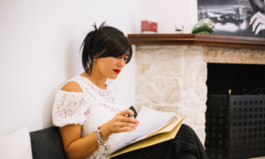 A woman reads financial documents on her couch