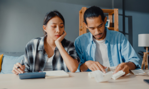 A young man and woman add up several receipts